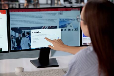 Junge Frau vor einem Computerbildschirm, die auf eine Schaltfläche klickt, um die Cookies der Website zu akzeptieren