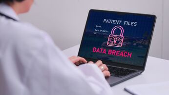 Ärztin am Laptop, auf dem Bildschirm eine Warnung „Patient Files – Data Breach“ mit Schloss-Symbol – Symbol für eine Datenpanne bei Patientendaten