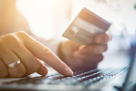 Woman's hand typing on laptop while doing online shopping