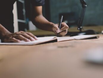 Checklist Writing Notice Remember Planning assessment Concept,home office desk background,hand holding pen and writing note on wood table.