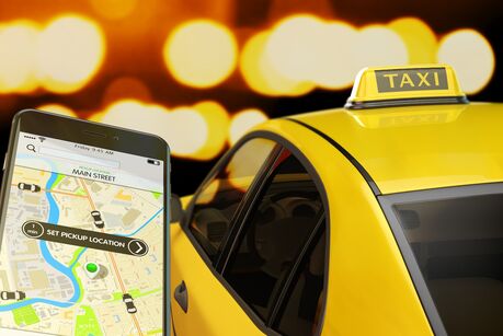 transportation network, modern smartphone with app for online taxi ordering service on screen, car with taxi sign at roof on street at night