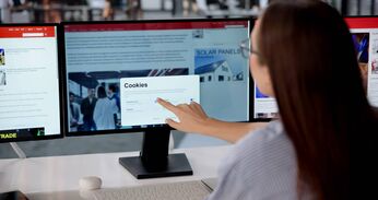 Junge Frau vor einem Computerbildschirm, die auf eine Schaltfläche klickt, um die Cookies der Website zu akzeptieren