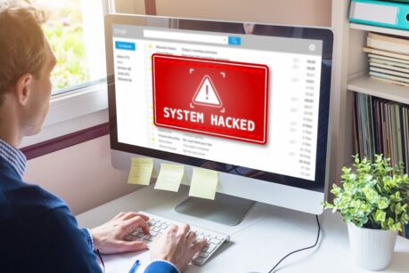 System hacked alert on computer screen after cyber attack on network. Cybersecurity vulnerability on internet, virus, data breach, malicious connection. Employee working in office