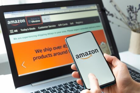 Kiew, Ukraine – 2. Februar 2021: Einkaufen im Amazon-Onlineshop mit Smartphone und Laptop.
